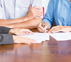 Photo of insurance papers being signed. Link to Gifts of Life Insurance.